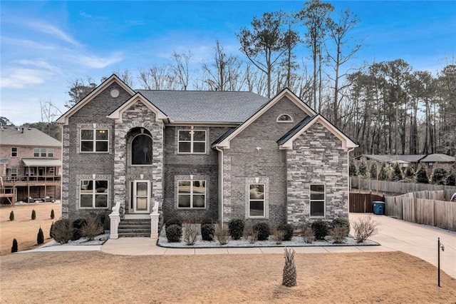 view of front of home with brick siding and fence