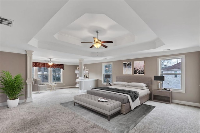 bedroom with crown molding, light colored carpet, a tray ceiling, and ornate columns