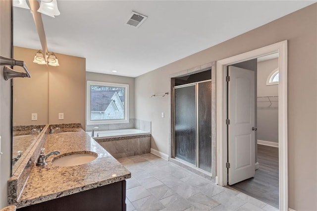 full bathroom featuring a garden tub, a shower stall, visible vents, and a sink