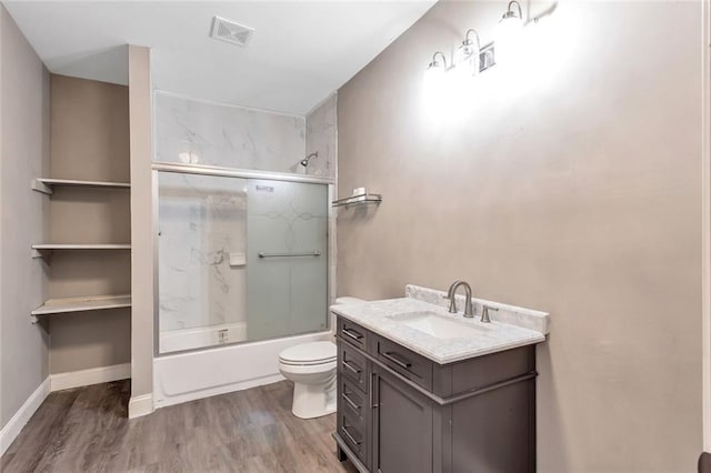 full bathroom featuring vanity, hardwood / wood-style floors, bath / shower combo with glass door, and toilet