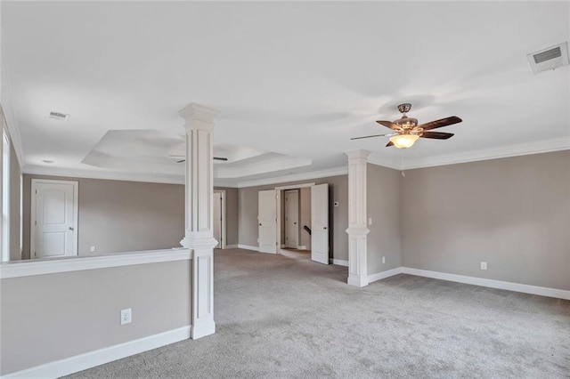 unfurnished room with a raised ceiling, visible vents, and ornate columns