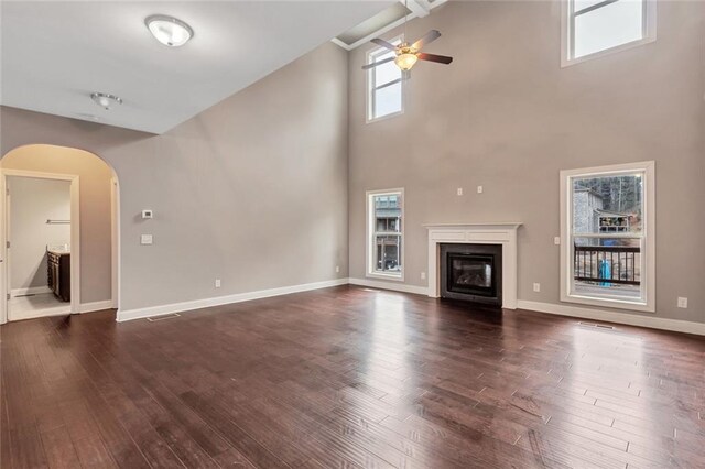 unfurnished living room featuring dark hardwood / wood-style flooring and ceiling fan