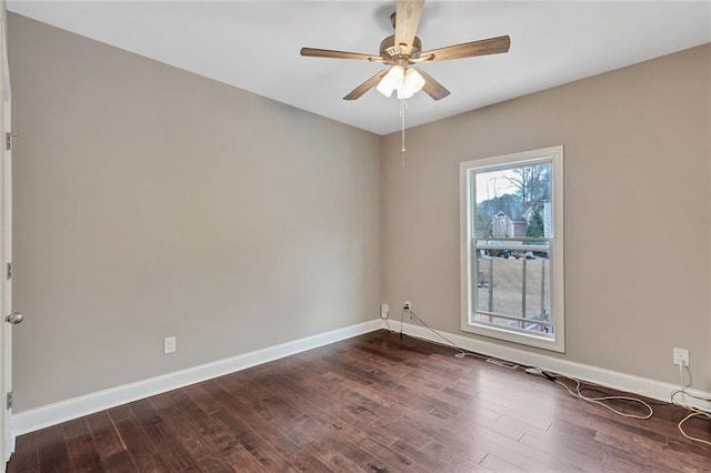 unfurnished room with ceiling fan, dark wood finished floors, and baseboards