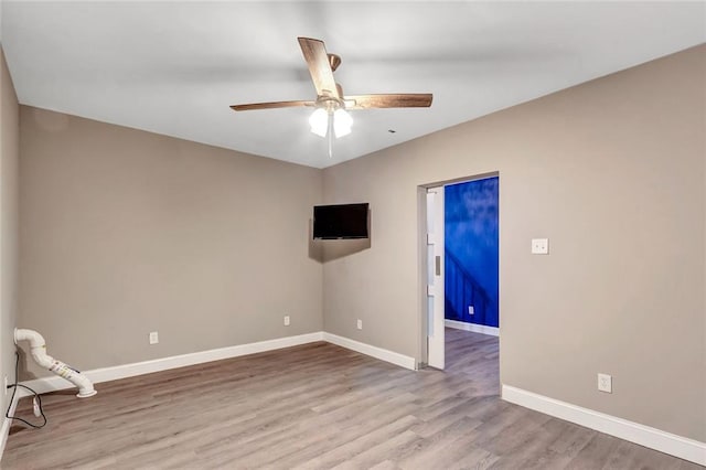 unfurnished room with ceiling fan, baseboards, and wood finished floors