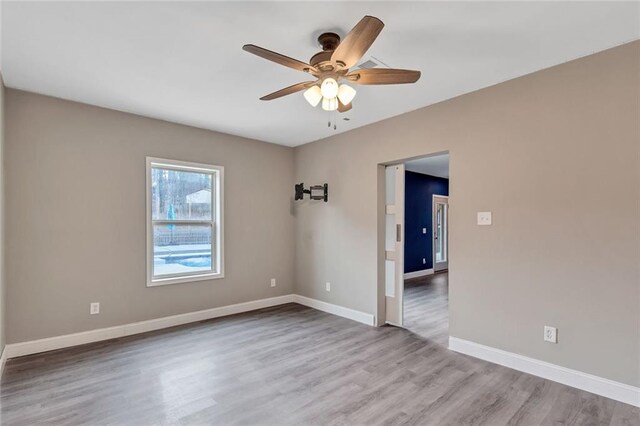 unfurnished room with ceiling fan and light wood-type flooring