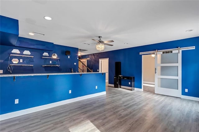 interior space with visible vents, ceiling fan, stairway, and a barn door