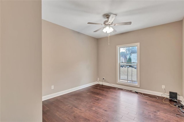 empty room with ceiling fan, dark wood-type flooring, and baseboards