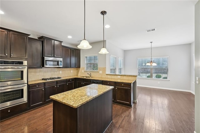 kitchen featuring pendant lighting, sink, dark brown cabinets, and stainless steel appliances