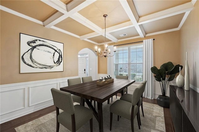 dining space with beamed ceiling, coffered ceiling, dark hardwood / wood-style flooring, and an inviting chandelier