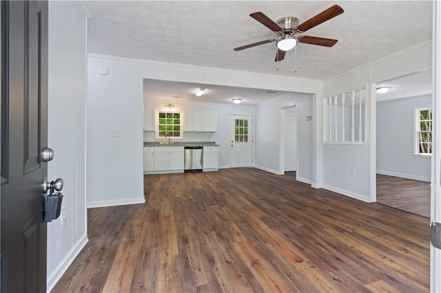 unfurnished living room with a textured ceiling, ceiling fan, crown molding, and dark hardwood / wood-style flooring