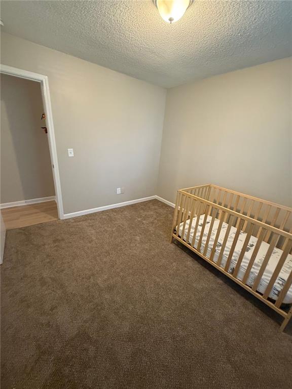 2661 Throatlatch Ln SW, Marietta, GA 30064 - unfurnished bedroom featuring carpet floors, a textured ceiling, and baseboards
