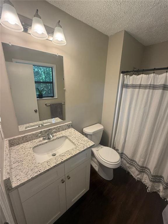 2661 Throatlatch Ln SW, Marietta, GA 30064 - full bath featuring wood finished floors, a textured ceiling, vanity, toilet, and a shower with shower curtain