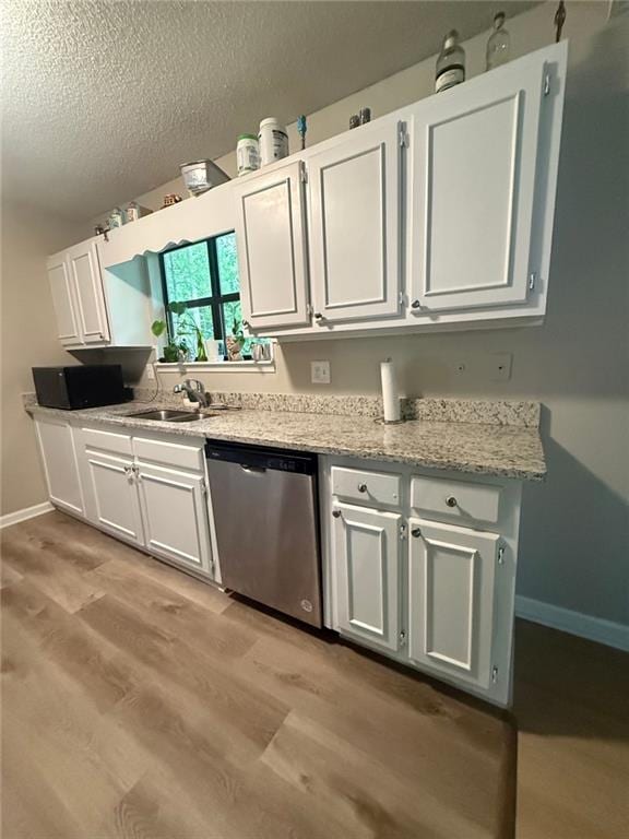 2661 Throatlatch Ln SW, Marietta, GA 30064 - kitchen with dishwasher, light wood-style floors, white cabinets, baseboards, and a textured ceiling