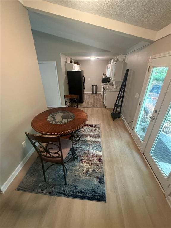 2661 Throatlatch Ln SW, Marietta, GA 30064 - dining room with light wood-style floors, a textured ceiling, and baseboards