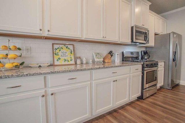 kitchen featuring stainless steel appliances, wood-type flooring, backsplash, ornamental molding, and white cabinets