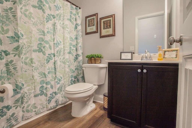 bathroom with hardwood / wood-style flooring, vanity, a shower with curtain, and toilet