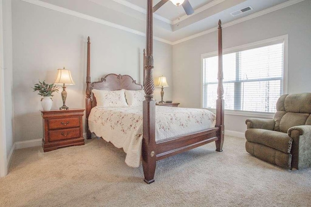 bedroom featuring a raised ceiling, ornamental molding, carpet, and ceiling fan