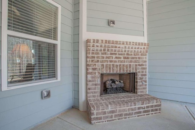 room details featuring a brick fireplace and wooden walls