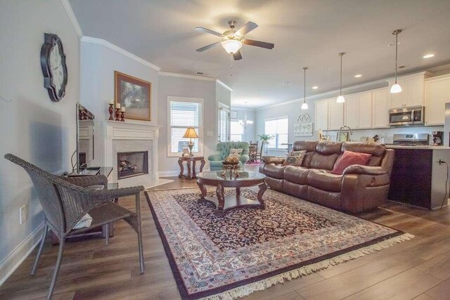 living room featuring ornamental molding, ceiling fan, a high end fireplace, and dark hardwood / wood-style flooring