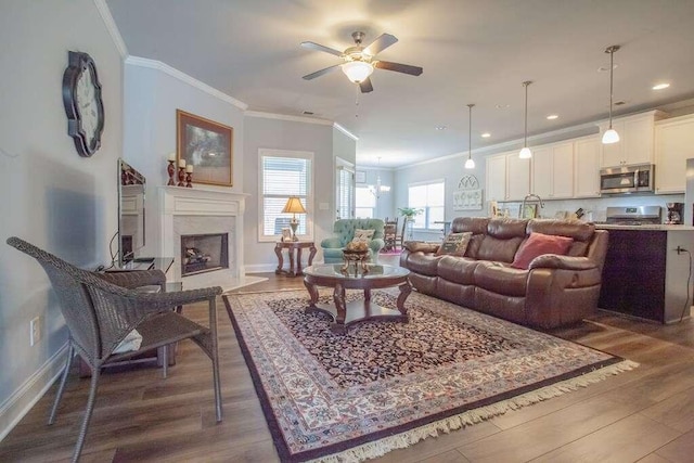 living room featuring a fireplace, ornamental molding, ceiling fan, and dark hardwood / wood-style flooring