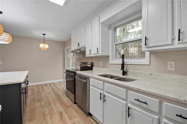 kitchen featuring stainless steel appliances, sink, white cabinets, and hanging light fixtures