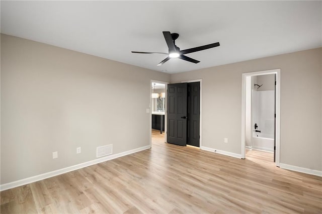 unfurnished bedroom featuring ensuite bathroom, light hardwood / wood-style flooring, and ceiling fan