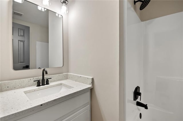 bathroom featuring washtub / shower combination and vanity