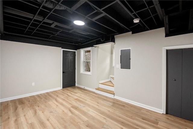 basement featuring light hardwood / wood-style floors and electric panel