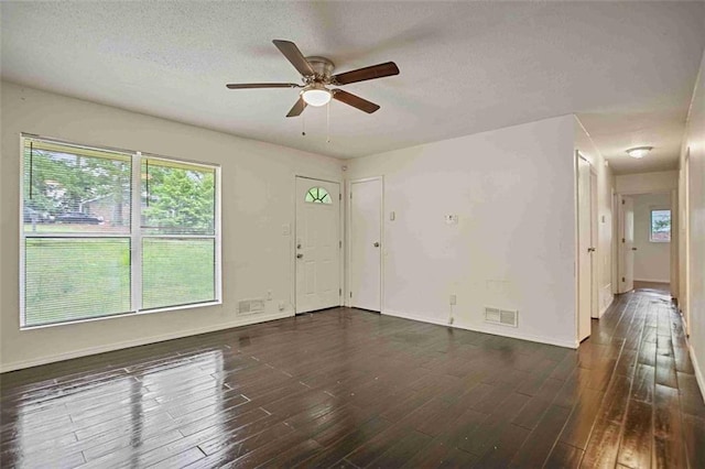 unfurnished living room with ceiling fan, wood finished floors, a textured ceiling, and baseboards