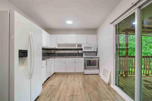 kitchen featuring white appliances, white cabinetry, light wood finished floors, and a sink