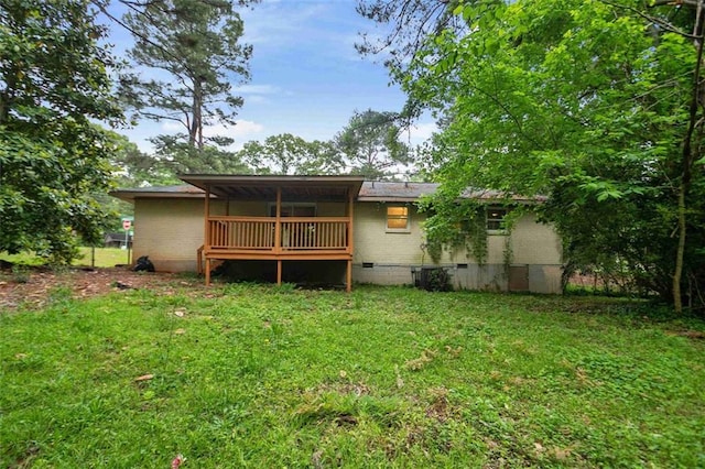 rear view of house with crawl space and a yard