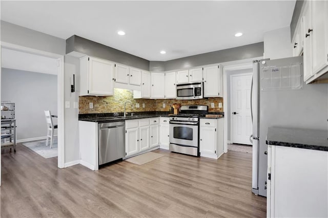 kitchen featuring stainless steel appliances, white cabinetry, and light hardwood / wood-style flooring