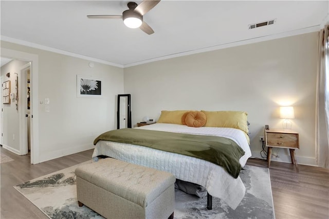 bedroom featuring ceiling fan, hardwood / wood-style flooring, and crown molding