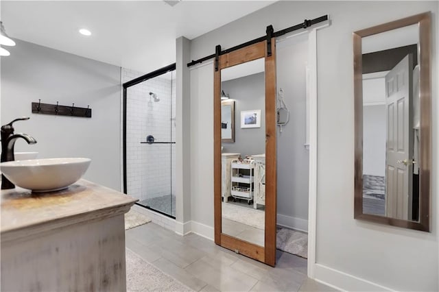 bathroom featuring a shower with door and vanity