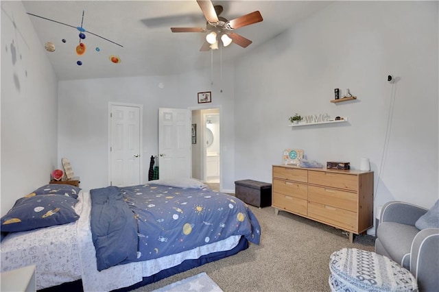 carpeted bedroom with ceiling fan, ensuite bathroom, and high vaulted ceiling