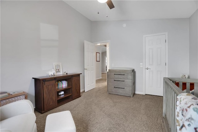 carpeted bedroom with lofted ceiling, ceiling fan, and a crib