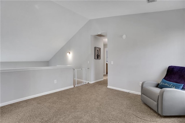 living area featuring vaulted ceiling and carpet