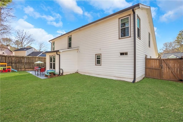 back of house featuring a patio area and a lawn