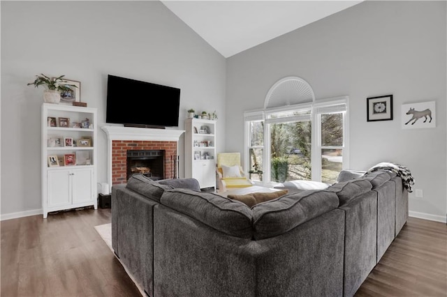 living room featuring dark hardwood / wood-style flooring, a brick fireplace, and high vaulted ceiling