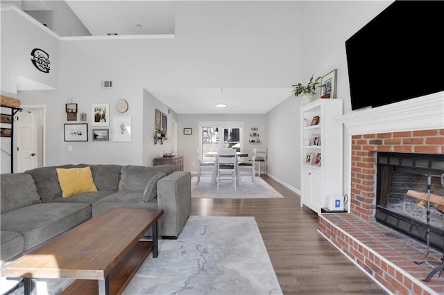 living room featuring hardwood / wood-style floors and a brick fireplace