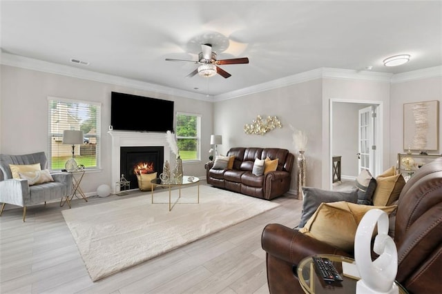 140 Canyons Ct, Hampton, GA 30228 - living room featuring healthy amount of natural light, ceiling fan, light wood finished floors, a lit fireplace, and crown molding