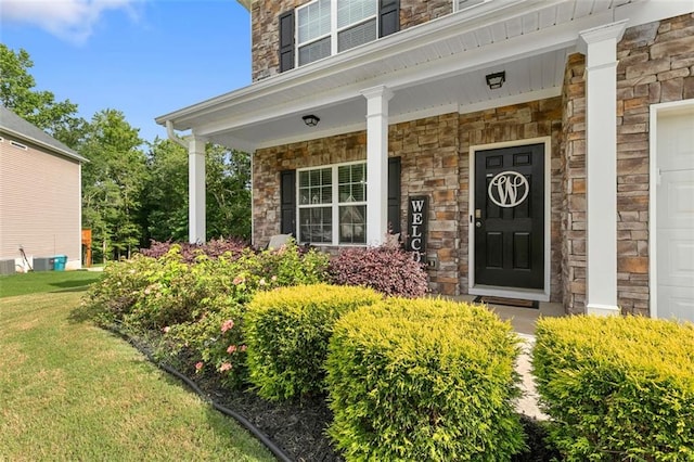 140 Canyons Ct, Hampton, GA 30228 - doorway to property with stone siding, covered porch, a garage, and a yard