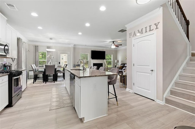 140 Canyons Ct, Hampton, GA 30228 - kitchen with stainless steel appliances, a ceiling fan, a breakfast bar area, ornamental molding, and recessed lighting