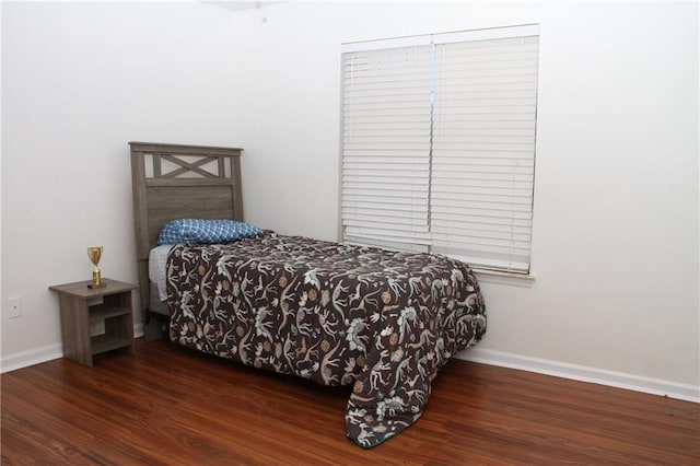 bedroom with baseboards and wood finished floors