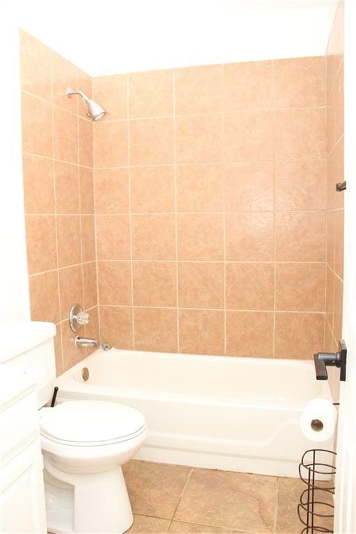 full bath with tub / shower combination, toilet, and tile patterned floors