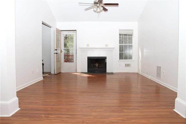 unfurnished living room featuring lofted ceiling, ceiling fan, wood finished floors, visible vents, and a tiled fireplace