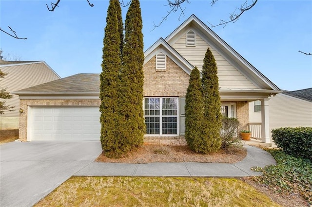 view of front of property featuring an attached garage, concrete driveway, and brick siding