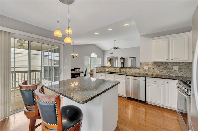 kitchen with vaulted ceiling, appliances with stainless steel finishes, plenty of natural light, and a sink