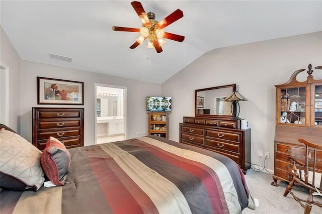 carpeted bedroom featuring ensuite bath, visible vents, vaulted ceiling, and a ceiling fan