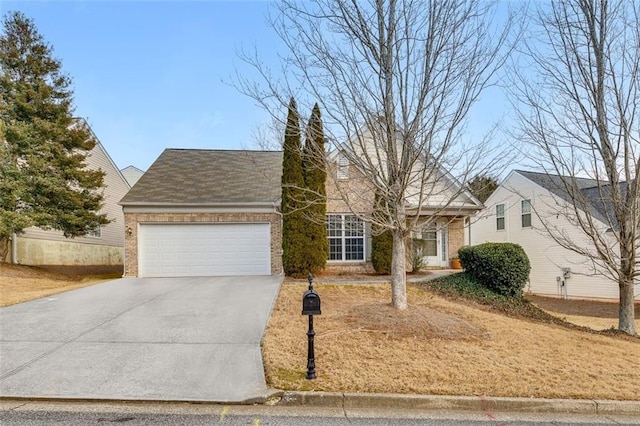 view of front facade featuring driveway, brick siding, and an attached garage